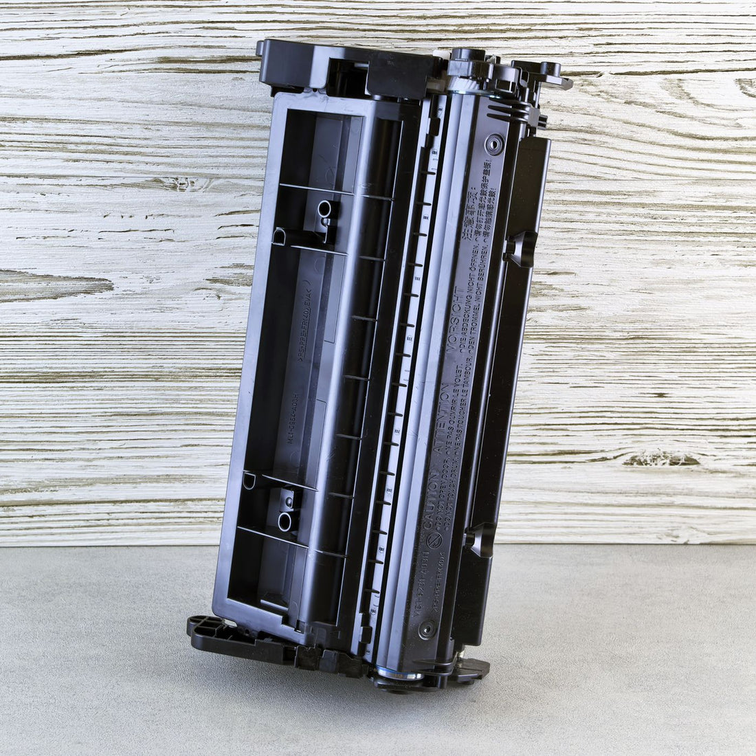 A black laser toner cartridge on a desk